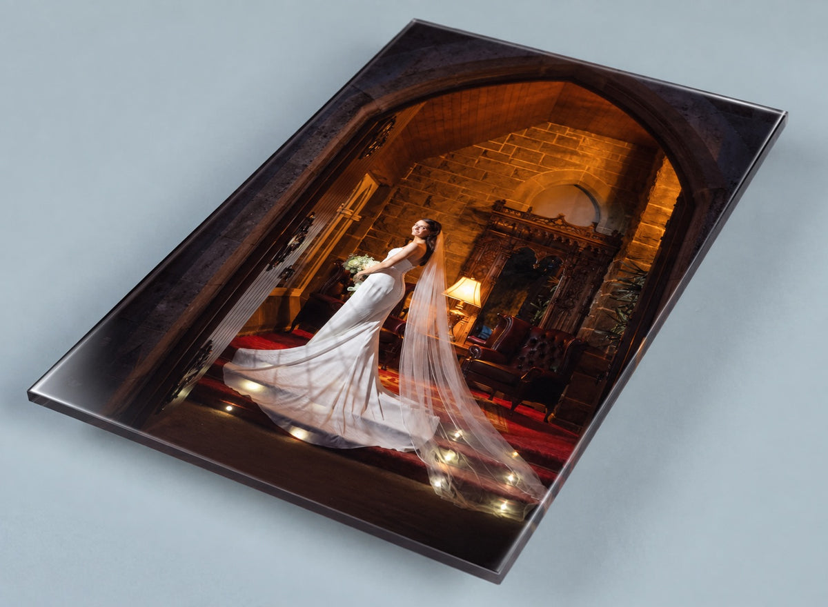 Angled view of a high-gloss acrylic wall print of a bride in a candlelit castle doorway