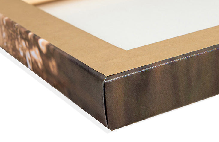 Close-up of a canvas print corner showing the neatly folded canvas over the oak frame