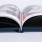 Deep Sea Blue velvet coffee table book lying open, showing its printed wedding photo pages