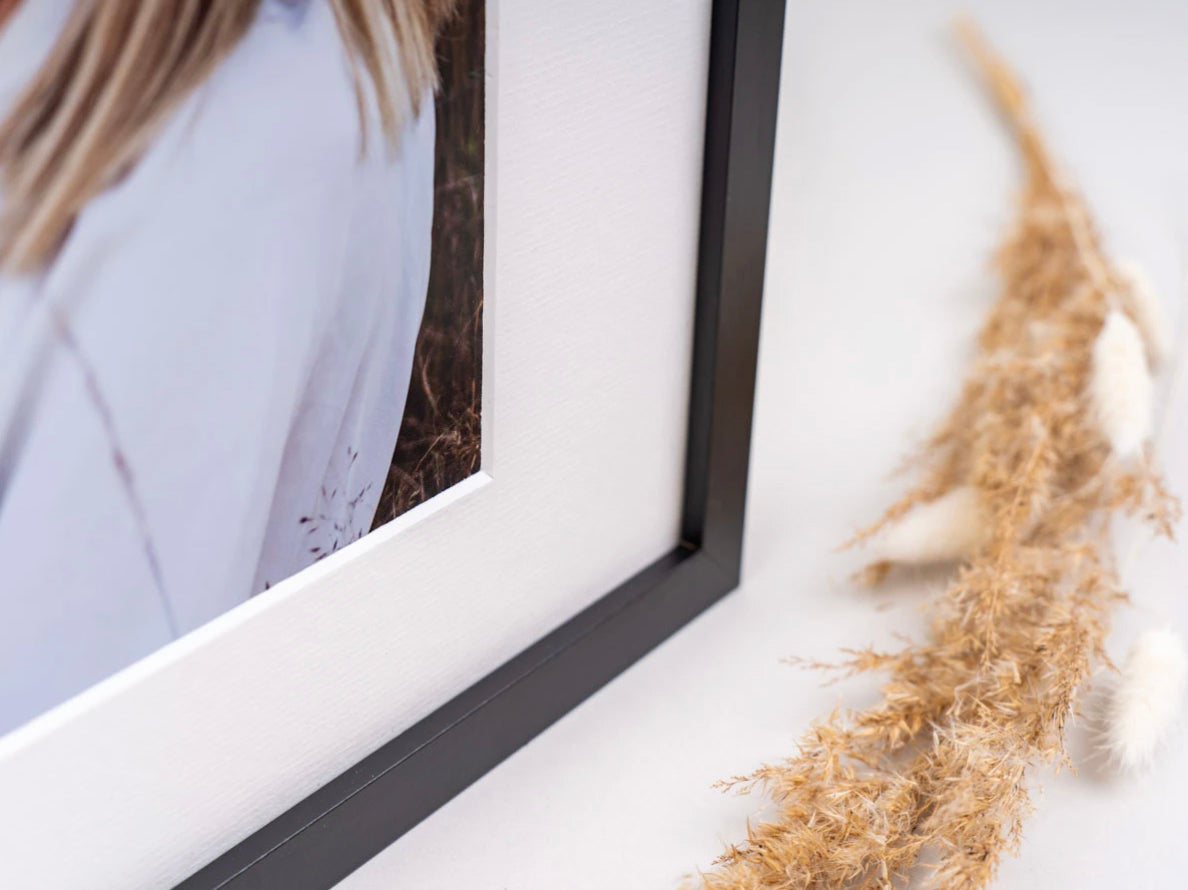 Close-up of a black photo frame and white mount