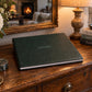 Hunter Green leatherette landscape wedding album with cover engraving on an antique wooden dresser
