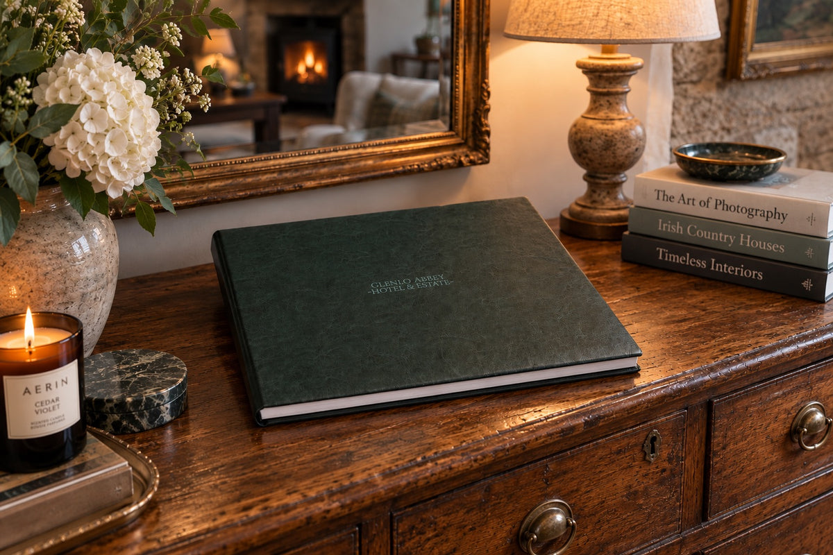 Hunter Green leatherette landscape wedding album with cover engraving on an antique wooden dresser