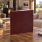Burgundy leatherette wedding album standing on a rustic wooden coffee table in a cosy living room