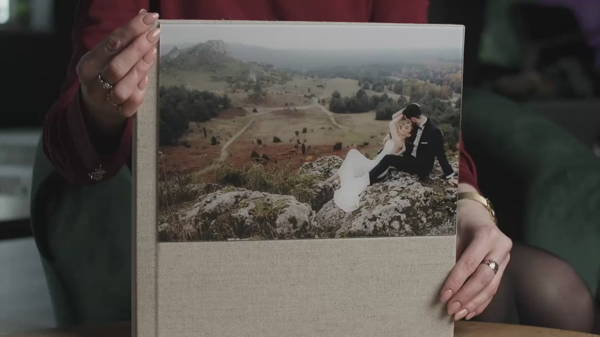 Acrylic photo cover wedding album held in hand, with a half-page acrylic panel showing the couple's wedding photo on a Cappuccino linen cover