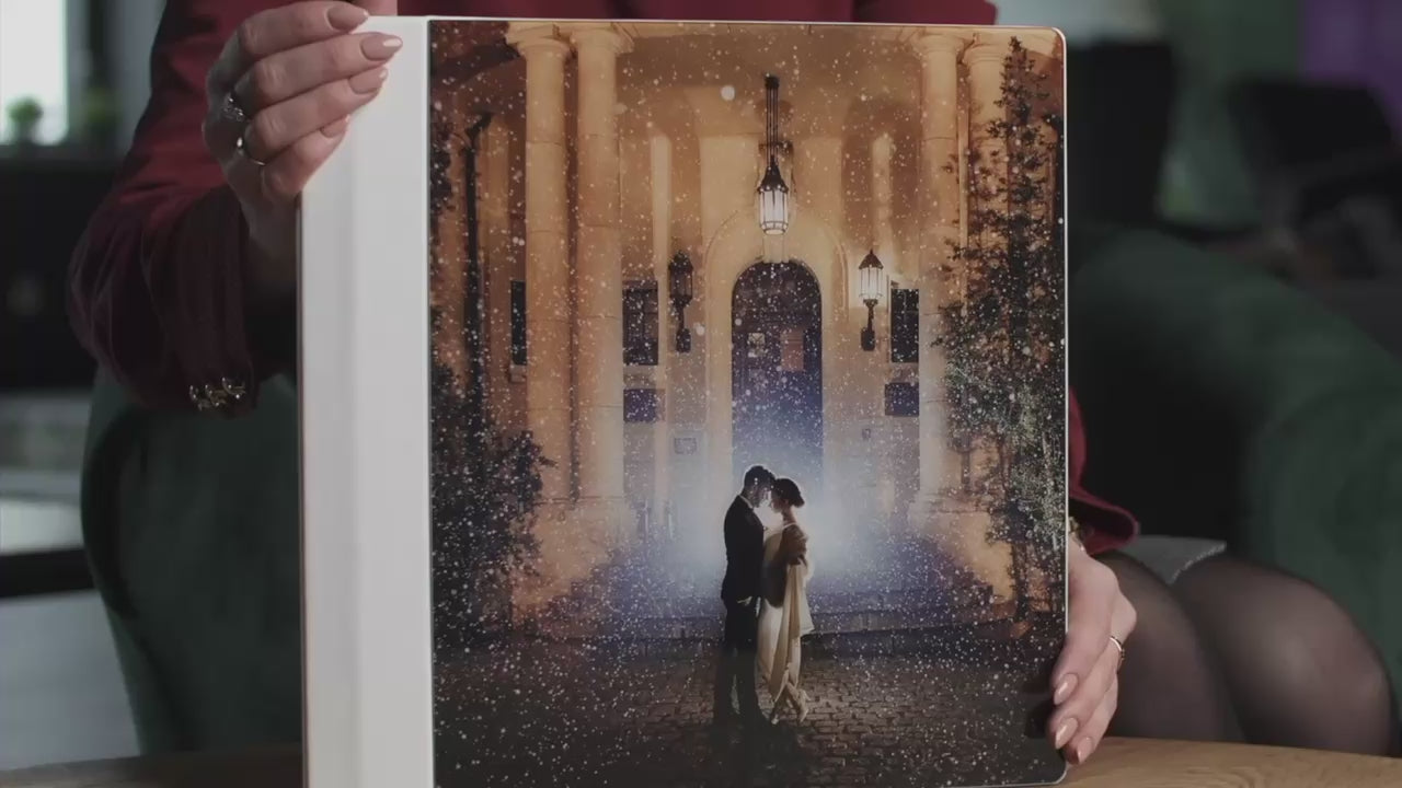 Acrylic photo cover wedding album held in hand, with a full-page acrylic front showing the couple's wedding photo and a Frothy White vegan leatherette spine